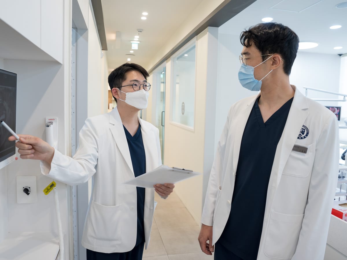 연세내일치과의원 지축 원장 두 명이 파노라마 영상을 함께 보며 논의하는 모습